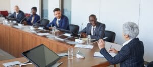 Executive leadership team discussing strategic communications, stakeholder engagement, and business strategy during a boardroom meeting.